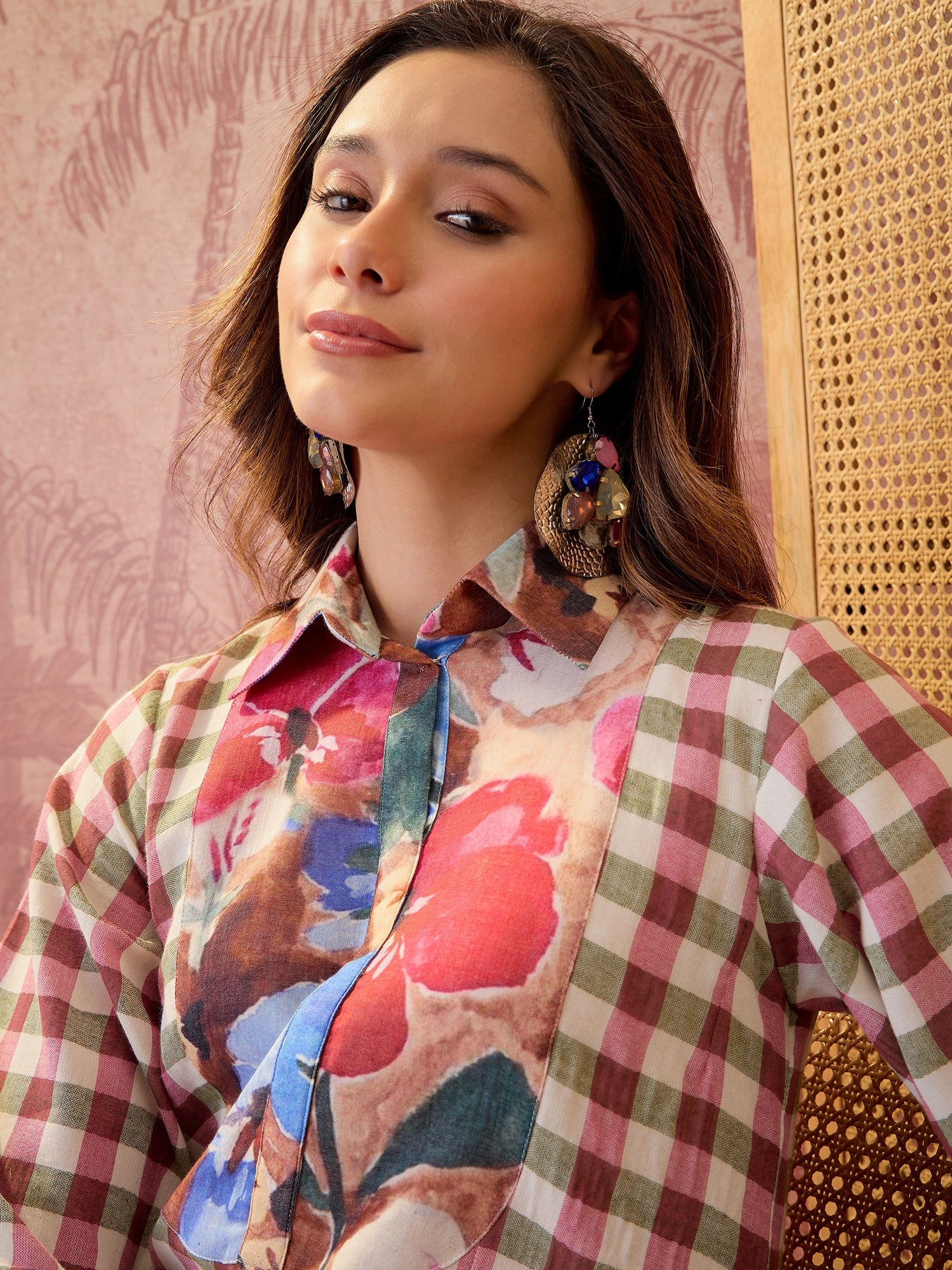 Woman wearing a pink jacquard check midi shirt dress with multicolour floral printed bib panel and relaxed silhouette.