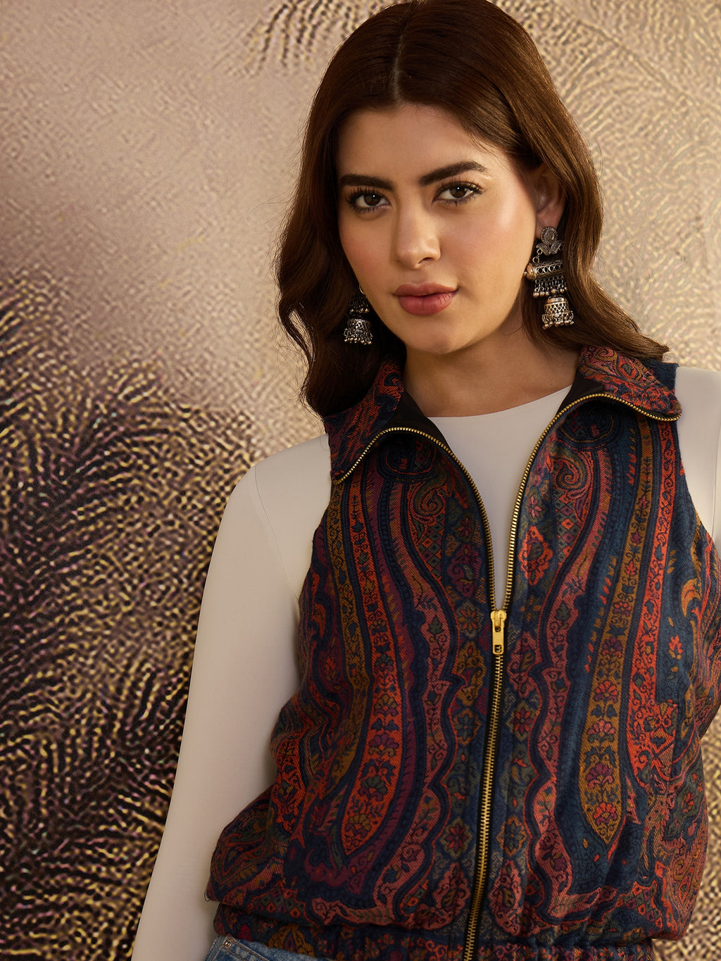 Woman wearing a patterned vest against a textured gold background