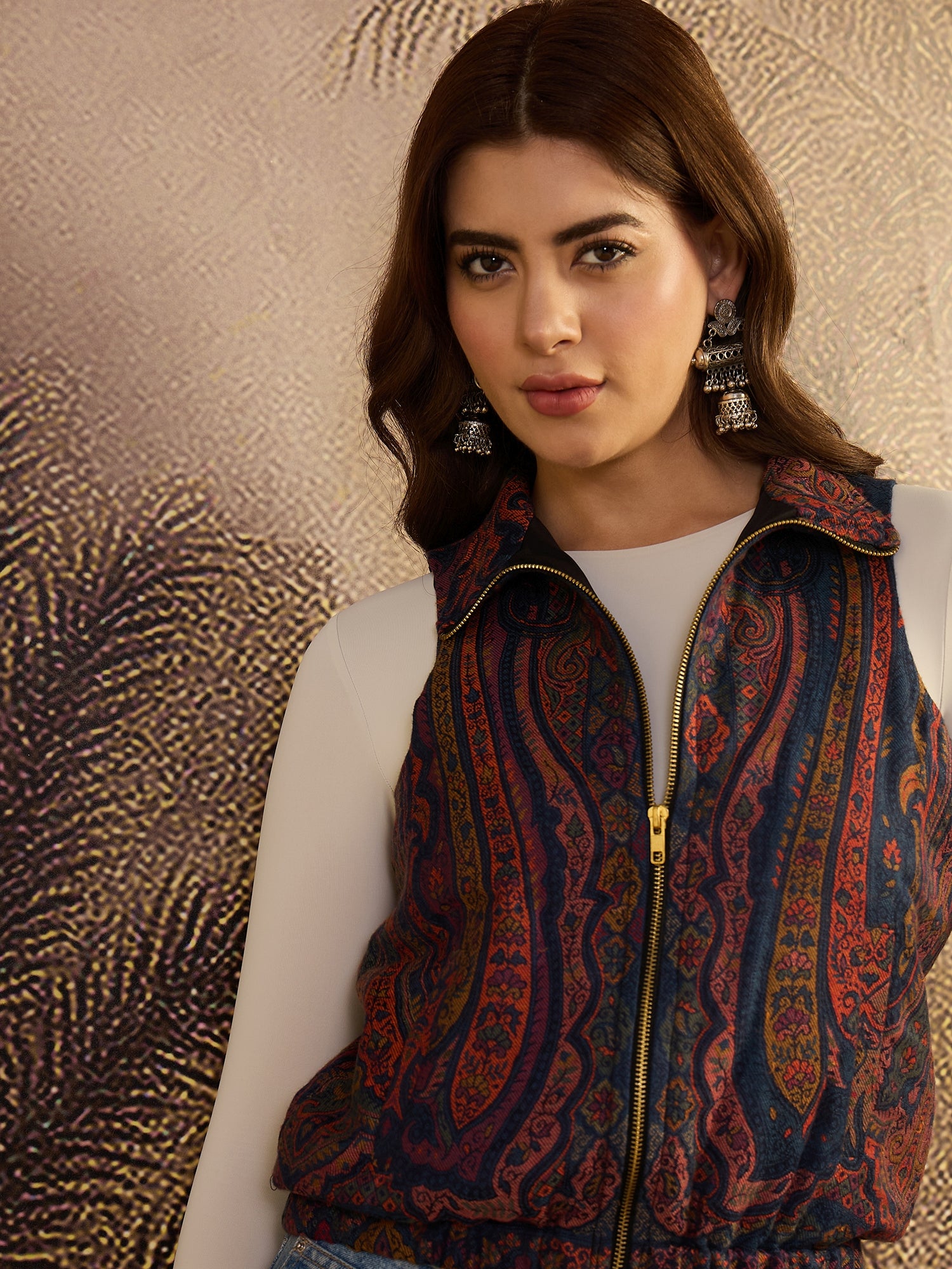 Woman wearing a patterned vest against a textured gold background
