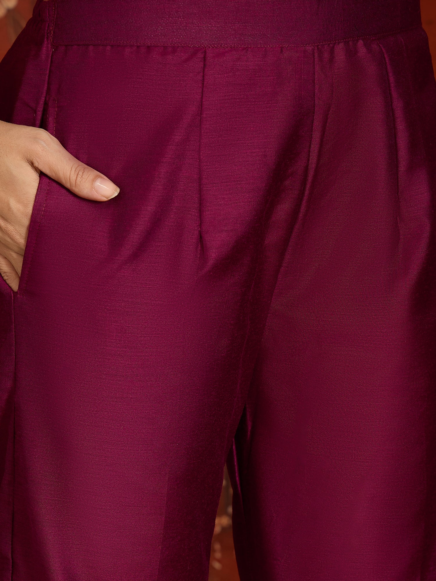 Woman wearing the Rangmahal Zari Woven Co-Ord Set in a rich wine hue featuring intricate zari-woven chevron motifs, decorative borders, and matching trousers for festive and contemporary occasions.