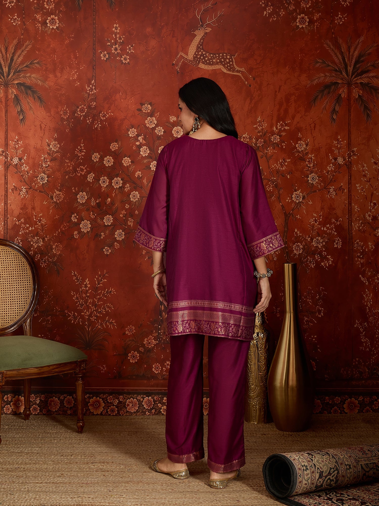 Woman wearing the Rangmahal Zari Woven Co-Ord Set in a rich wine hue featuring intricate zari-woven chevron motifs, decorative borders, and matching trousers for festive and contemporary occasions.