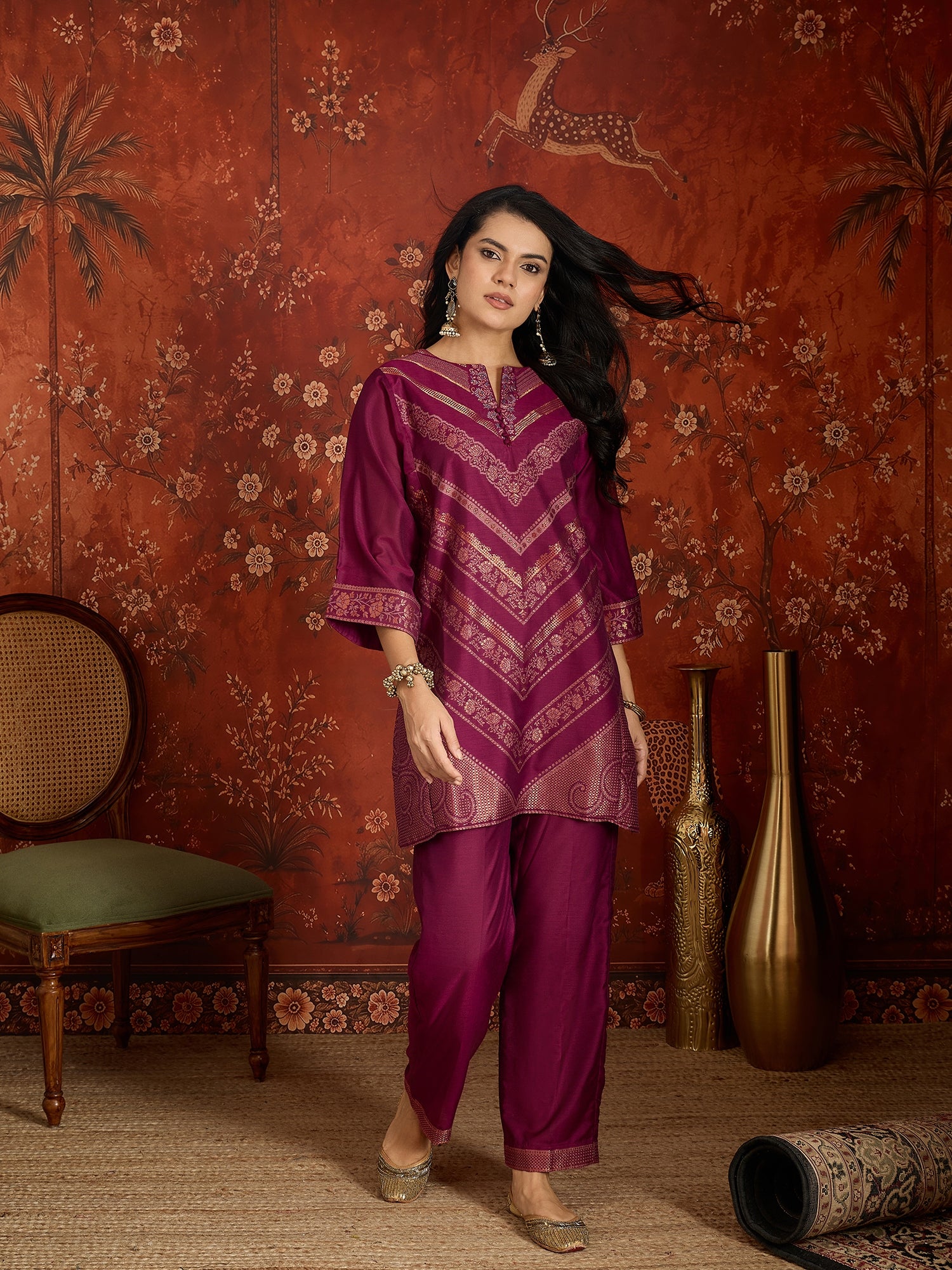 Woman wearing the Rangmahal Zari Woven Co-Ord Set in a rich wine hue featuring intricate zari-woven chevron motifs, decorative borders, and matching trousers for festive and contemporary occasions.