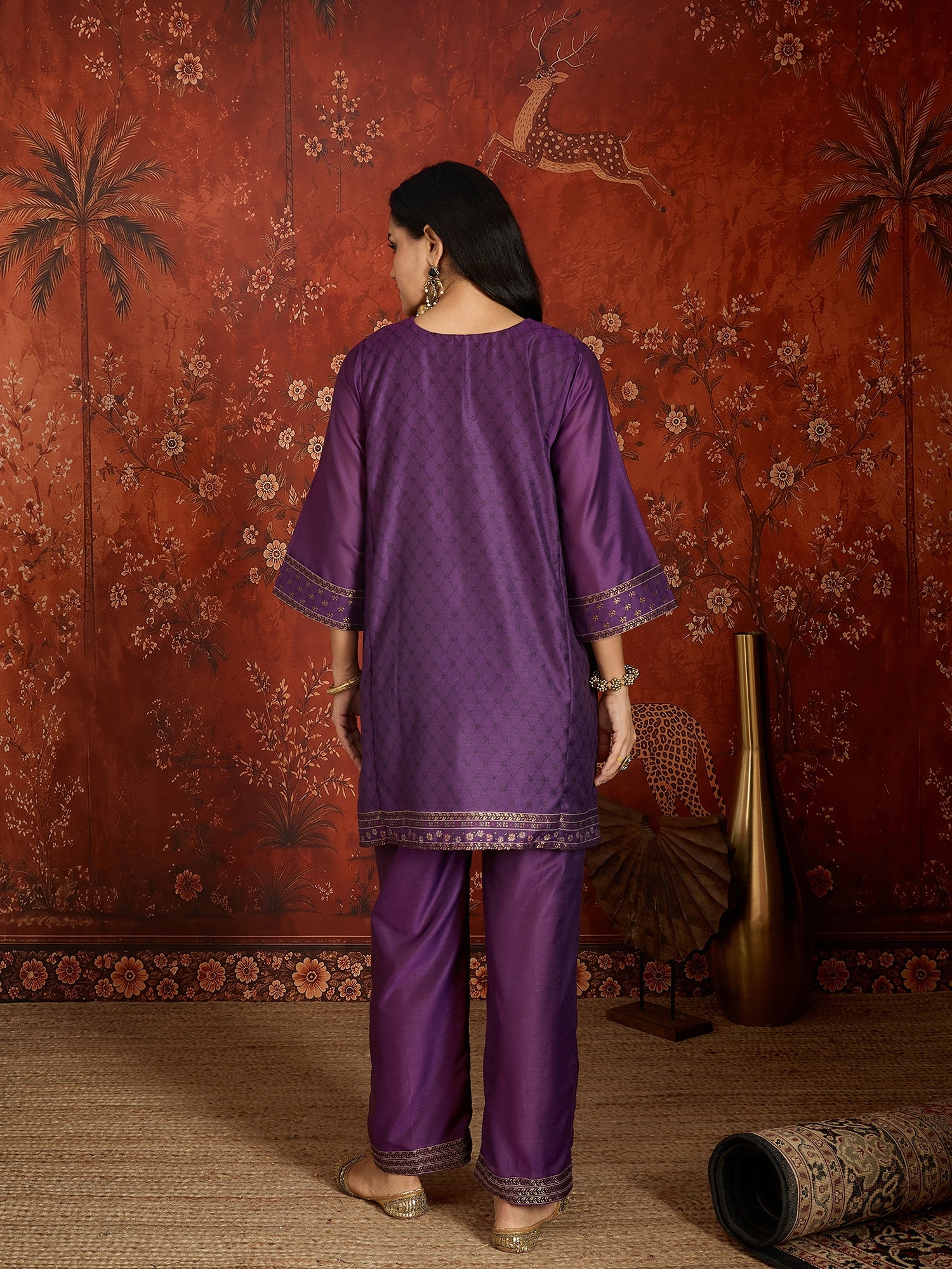 Woman wearing the Gulnaar Zari Woven Co-Ord Set in royal purple featuring intricate zari-woven motifs and matching trousers, styled for festive occasions and elegant contemporary wear.