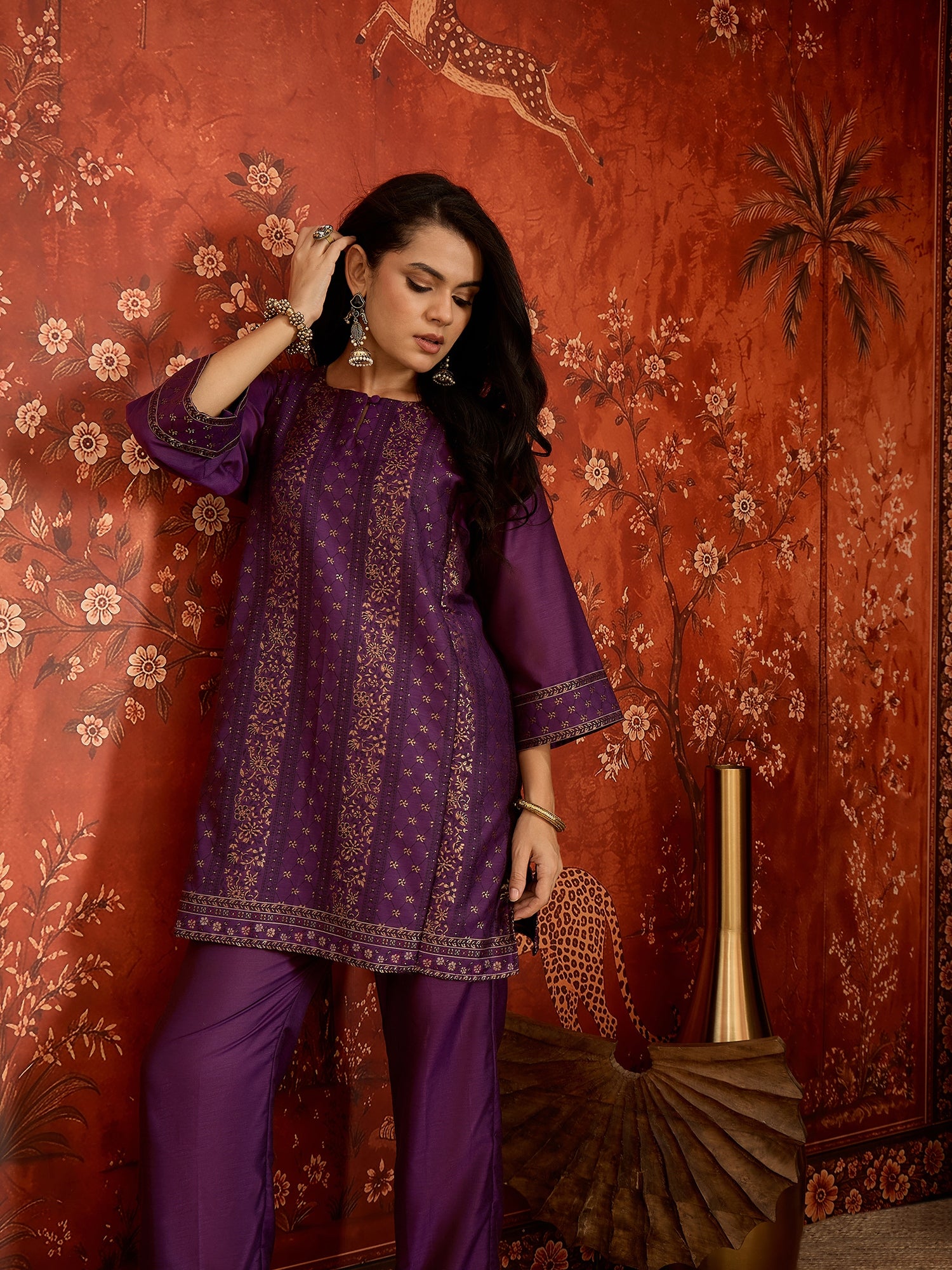 Woman wearing the Gulnaar Zari Woven Co-Ord Set in royal purple featuring intricate zari-woven motifs and matching trousers, styled for festive occasions and elegant contemporary wear.