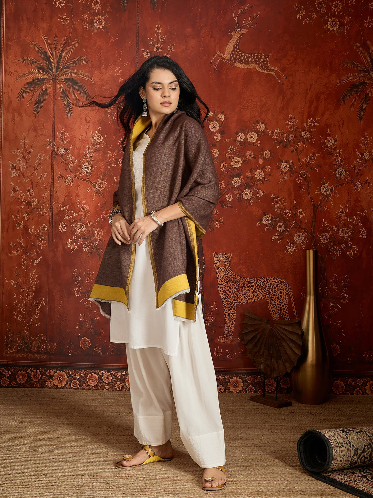 Woman wearing a reversible brown and mustard colorblocked wool blend stole draped over a white kurta, showcasing its soft texture and versatile dual-tone design.