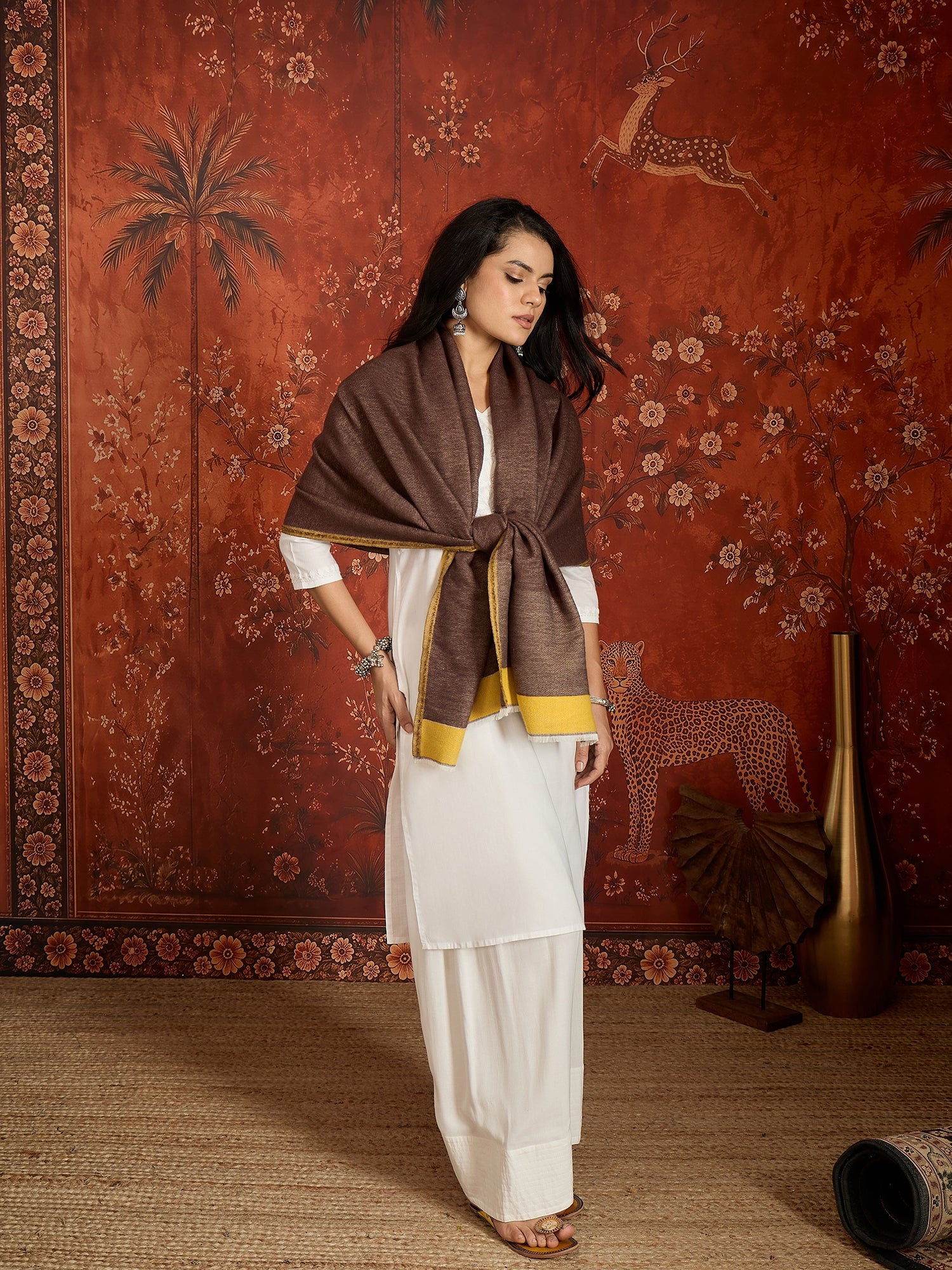 Woman wearing a reversible brown and mustard colorblocked wool blend stole draped over a white kurta, showcasing its soft texture and versatile dual-tone design.