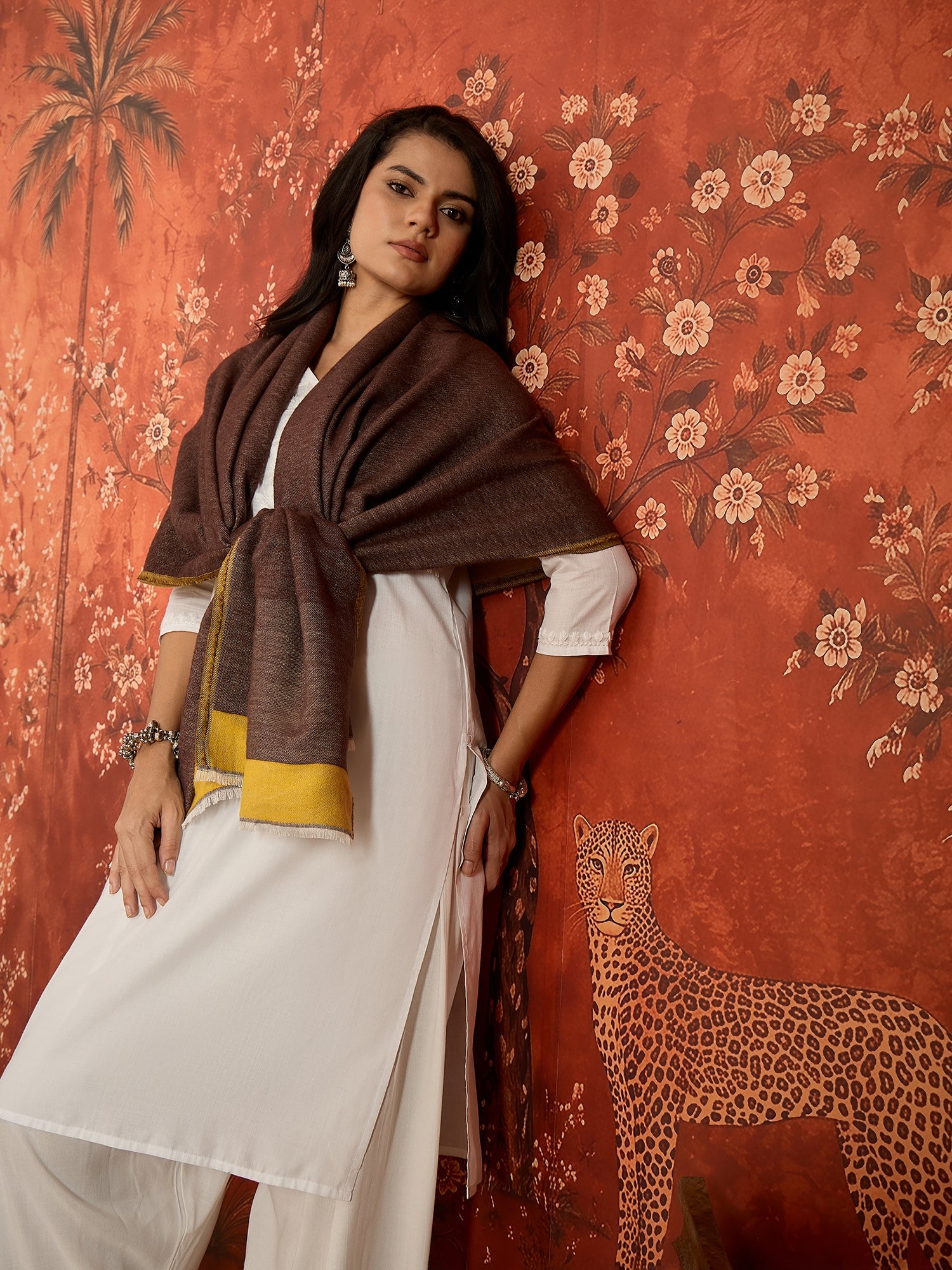 Woman wearing a reversible brown and mustard colorblocked wool blend stole draped over a white kurta, showcasing its soft texture and versatile dual-tone design.