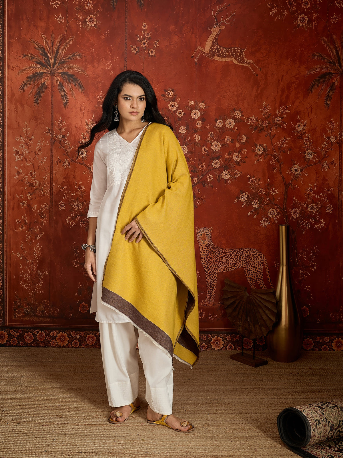 Woman wearing a reversible brown and mustard colorblocked wool blend stole draped over a white kurta, showcasing its soft texture and versatile dual-tone design.