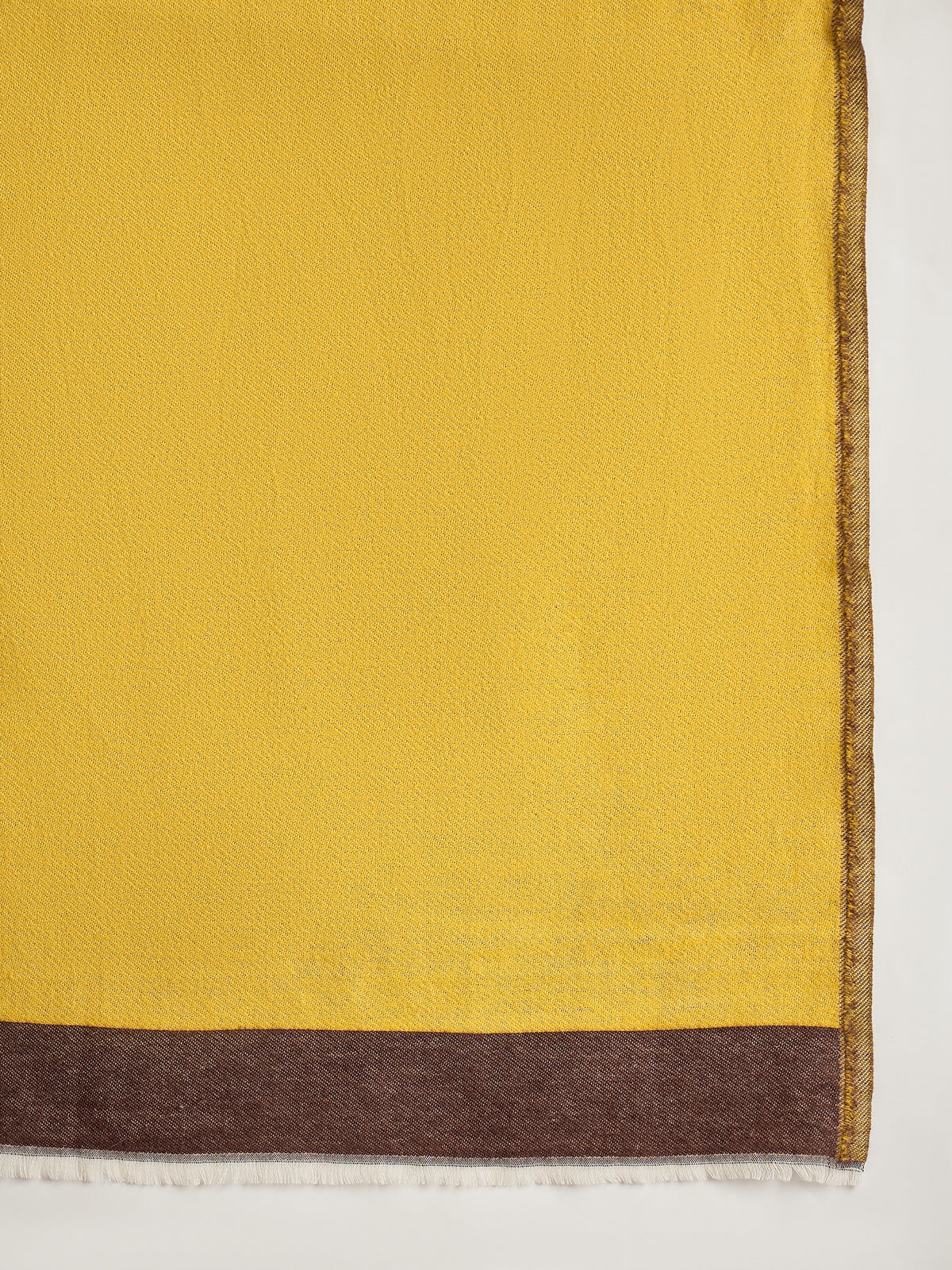 Woman wearing a reversible brown and mustard colorblocked wool blend stole draped over a white kurta, showcasing its soft texture and versatile dual-tone design.