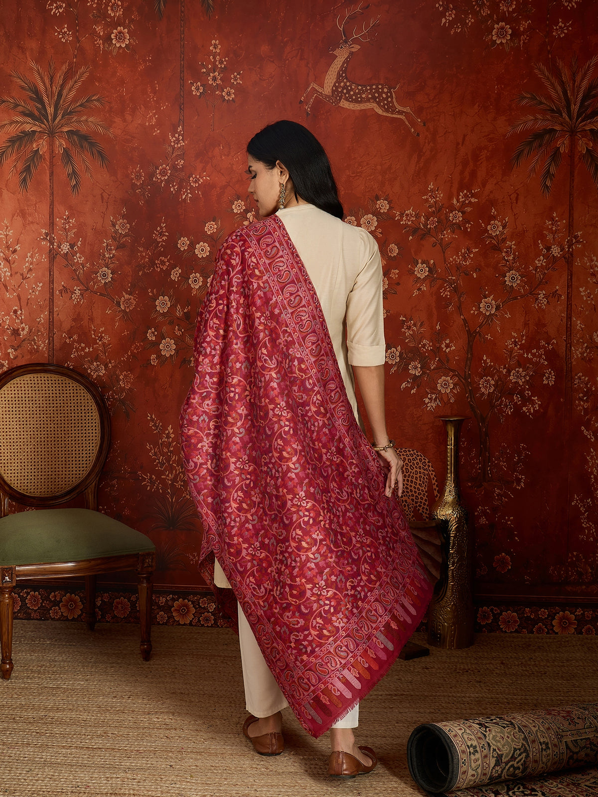 Woman draped in a maroon Kashmiri woven stole featuring intricate paisley and floral jacquard motifs with elegant ornamental borders.