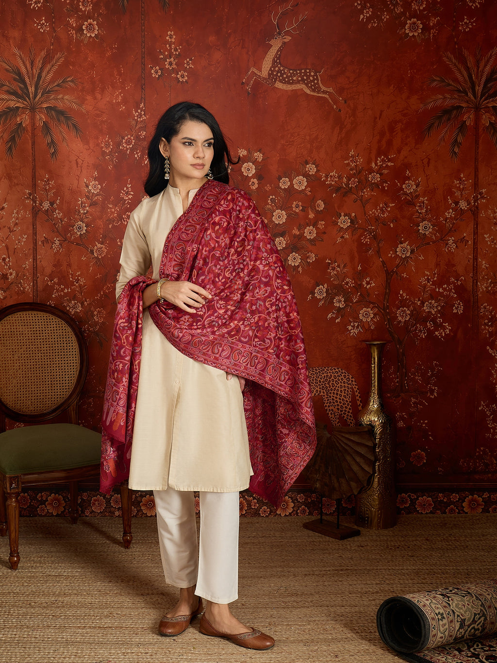 Woman draped in a maroon Kashmiri woven stole featuring intricate paisley and floral jacquard motifs with elegant ornamental borders.
