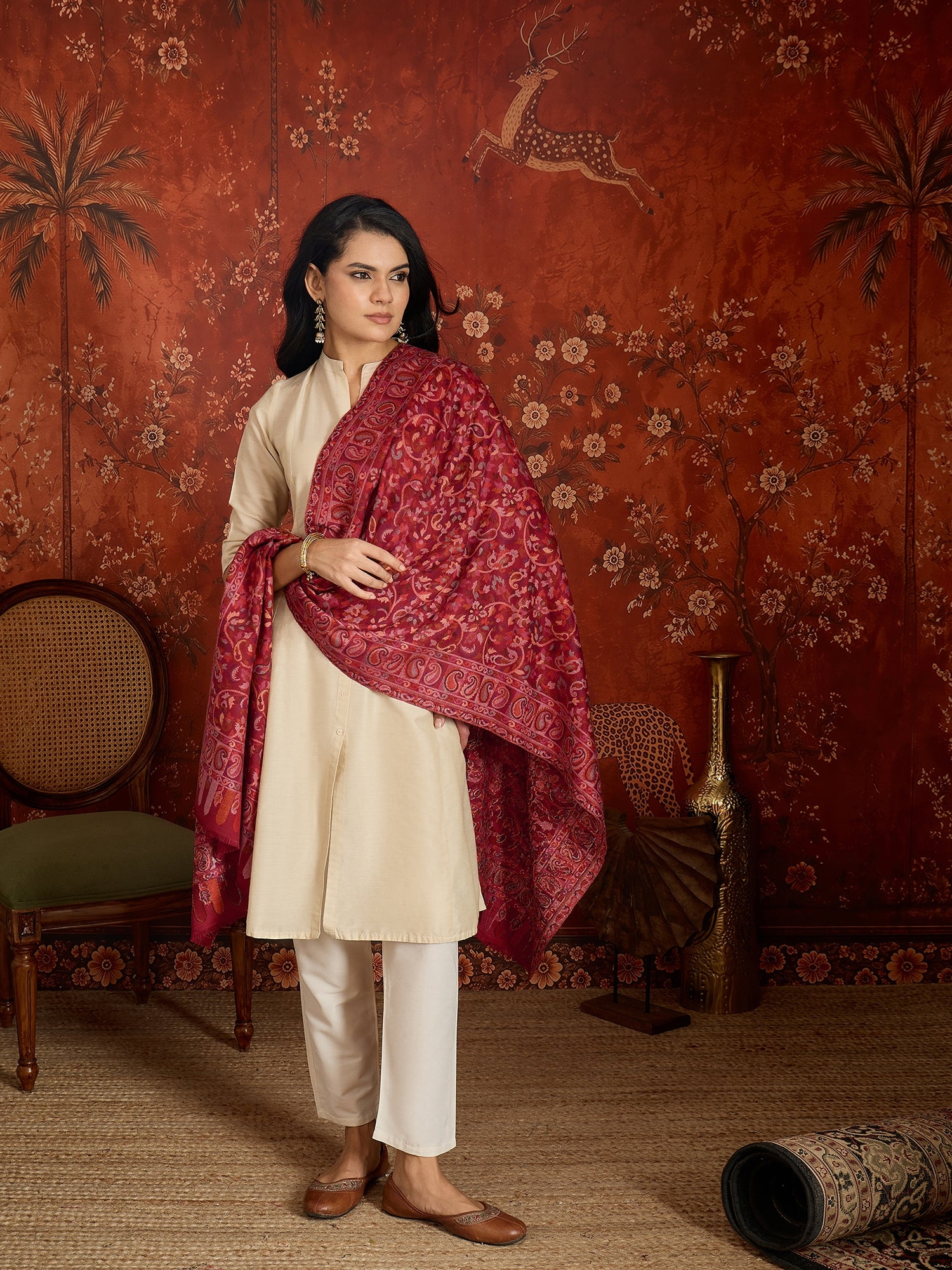 Woman draped in a maroon Kashmiri woven stole featuring intricate paisley and floral jacquard motifs with elegant ornamental borders.