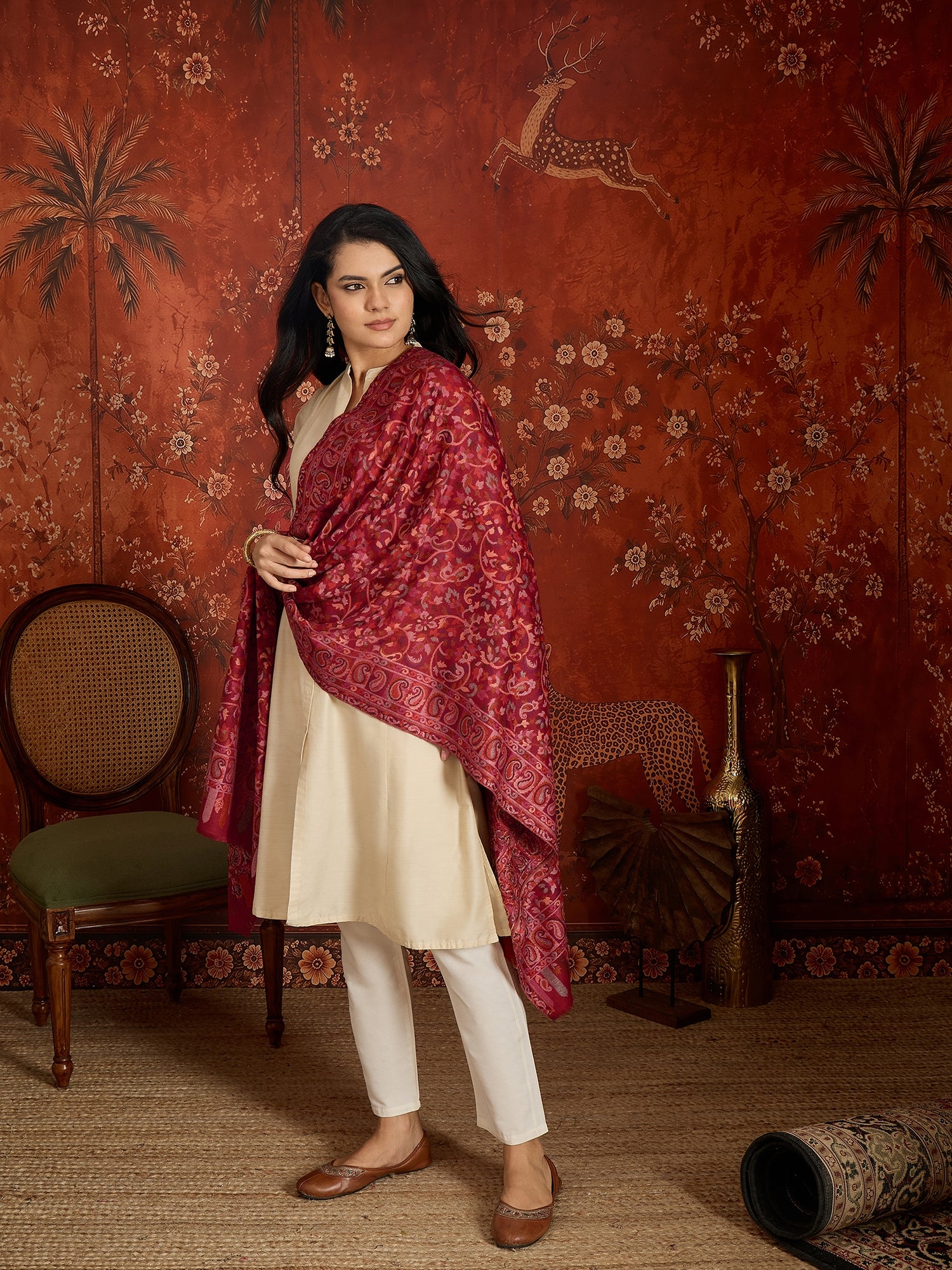 Woman draped in a maroon Kashmiri woven stole featuring intricate paisley and floral jacquard motifs with elegant ornamental borders.