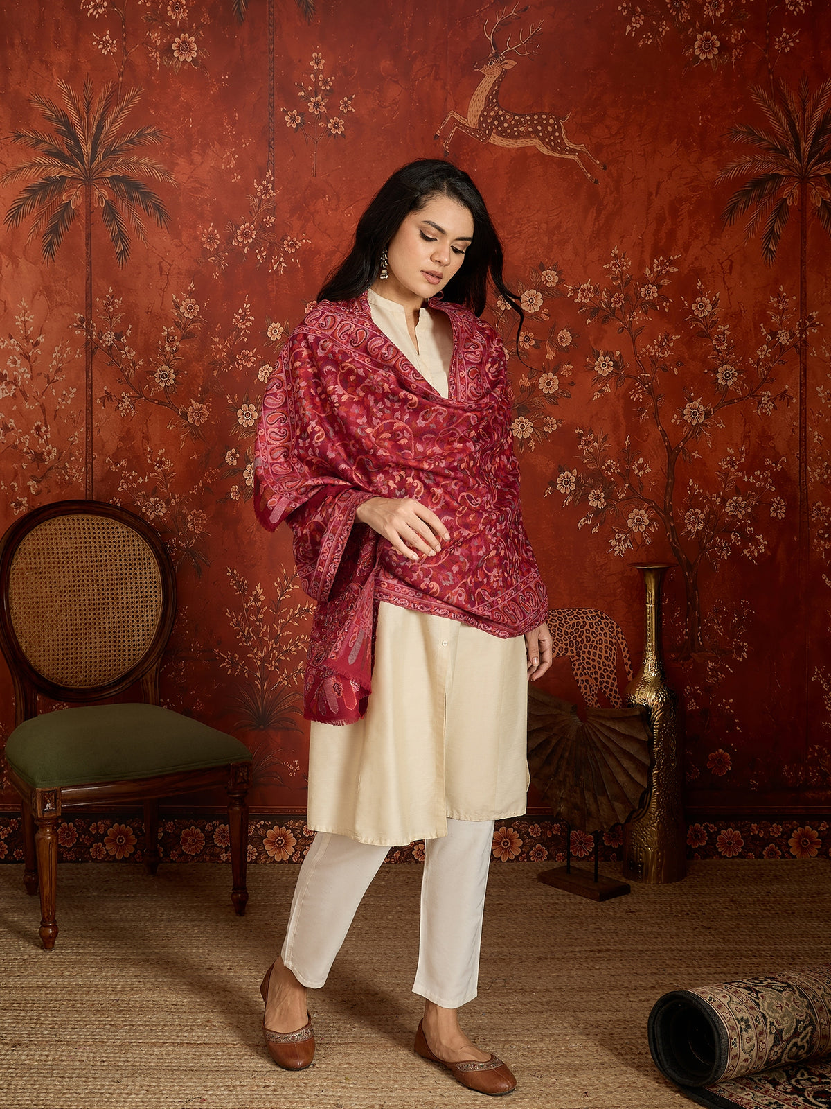 Woman draped in a maroon Kashmiri woven stole featuring intricate paisley and floral jacquard motifs with elegant ornamental borders.
