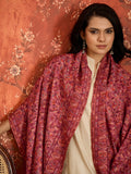 Woman draped in a Gajjari pink Kashmiri Kaani stole featuring intricate woven paisley motifs and traditional jacquard craftsmanship.